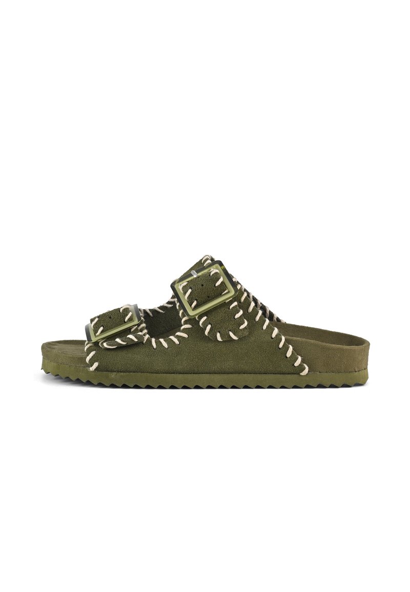 Green suede slide sandals with dual buckles, white stitching details, textured sole, and open design for breathability.