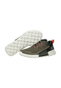 Olive green athletic shoes with mesh upper, white textured sole, red accents, black heel cap, and contrasting logo on side.