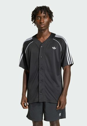 Zwart shirt met knoopsluiting aan de voorkant, voorzien van witte streepaccenten en een klein logo. Draagt bijpassende zwarte shorts van getextureerde stof.