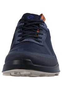 Front view of a navy blue athletic shoe with black laces, orange pull tab, mesh upper, and white textured sole.