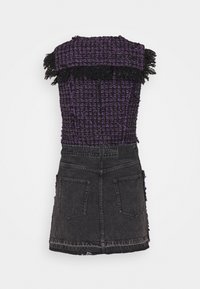 Lila och svart vävd klänning med fransade kanter, med en figurnära överdel och en utsvängd svart jeanskjol. Inkluderar bakfickor och varumärkesetikett.
