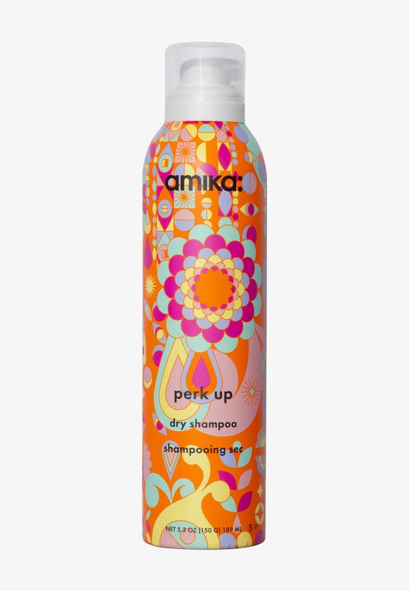 Un flacon de shampooing sec présente un fond orange avec des motifs floraux et géométriques colorés. Le texte comprend "perk up" et des détails sur le produit.