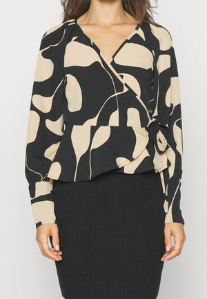 Blouse style wrap en noir et beige avec des motifs abstraits, manches longues, et un détail noué à la taille. Tissu lisse avec une coupe ample.