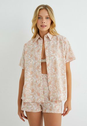Lyhythihainen nappiapapaita ja shortsit vaaleanpunaisessa värissä, joissa on paisley-kuvio. Valmistettu sileästä kankaasta, rento malli ja avokollari.