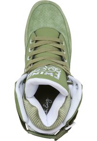 Zapatillas verdes con material de ante y sintético, con detalles perforados, acentos blancos y un diseño de caña alta con cierre de cordones.