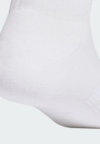 Calcetín blanco hasta el tobillo con textura de punto suave, diseño acanalado y talón y puntera reforzados para mayor durabilidad. Sin patrones ni detalles visibles.