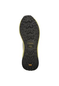 Svart gummisul med multidirektionella mönster, gula sidodetaljer och "Clarks ATL"-märke på mellemsulan.