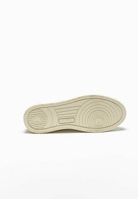 Suola di sneaker in gomma bianca con un motivo testurizzato, caratterizzato da design circolari e lineari. Nome del marchio "AUTRY" stampato in rilievo sulla suola intermedia.