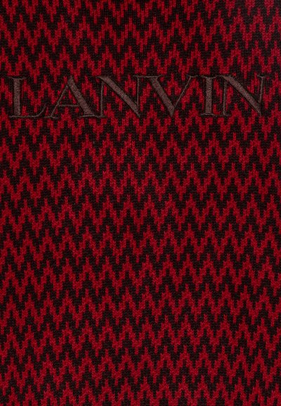 Raudonos ir juodos zigzaguotų raštų medžiaga su iškilniu "LANVIN" logotipu tamsiai rudos spalvos, turinti tekstūruotą mezginio išvaizdą.