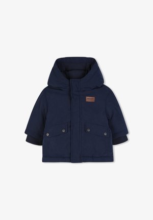 Veste matelassée à capuche bleu marine avec poches à rabat devant et petite étiquette logo Timberland marron sur la poitrine.