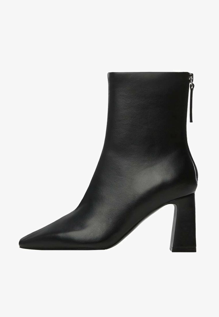 Bottine en cuir noir avec bout pointu, talon bloc et fermeture éclair au dos.