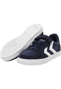 Navy sneakers med en blandning av canvas och mocka, vita detaljer, traditionella snören och en texturerad gummisula.