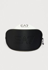 Čierne obdĺžnikové púzdro so zipsom s vyrazeným logom EA7, opreté o biele pozadie s logom EA7 Emporio Armani.