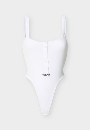 Fehér, ujjatlan bordázott body elülső gombokkal és a deréknál fekete "Versace" logó hímzéssel.