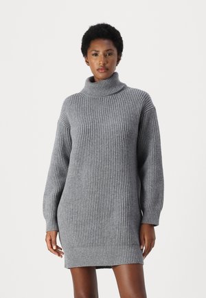 Graues, geripptes Strickkleid mit hohem Stehkragen, überschnittenen Schultern und langen Ärmeln; der strukturierte Stoff verleiht dem Design Tiefe.
