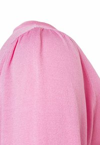 Haut en tricot rose clair avec une finition texturée, présentant des manches bouffantes et un détail de couture froncée au niveau de l'épaule.