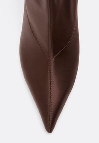 Braune Satin-Stoffschuhe mit spitzer Zehenpartie und sichtbaren Nahtstichen entlang der Mitte und der Seiten.
