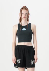 Haut court côtelé noir avec logo "OBEY" et short noir assorti avec surpiqûres blanches et accents imprimé animal sur les poches.