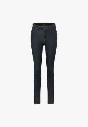 Donkerblauwe skinny jeans van denim. Heeft vijf zakken, een gulp met ritssluiting en contrasterend oranje stiksels langs de naden. Over het algemeen een gladde textuur.