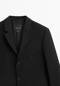 Zwart op maat gemaakte blazer met ingesneden revers, één borstzak, twee knopen en subtiele textuur. Label met de tekst "Massimo Dutti."
