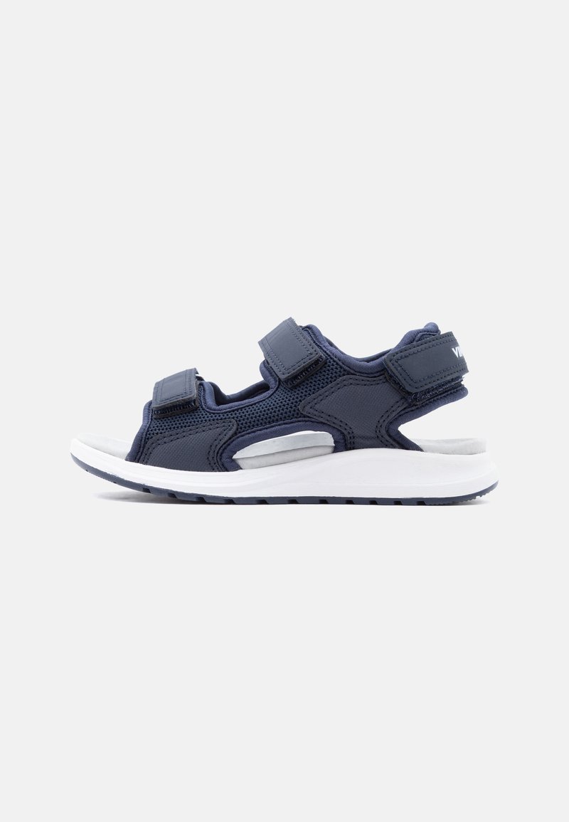 Αθλητικό σανδάλι σε ναυτικό μπλε με ρυθμιζόμενους ιμάντες βέλκρο, μαξιλαρωμένη σόλα και επάνω μέρος από διαπνέον δίχτυ, εμφανιζόμενο από το πλάι σε λευκό φόντο.