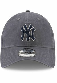Grå caps med justerbar stropp, med en hevet mørkeblå brodert "NY"-logo foran. Tekstilt materiale med buet brem.