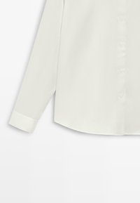 Wit overhemd met lange mouwen en knopen, met een enkele manchetknoop, getoond van half torso tot het uiteinde van de mouw op een witte achtergrond.