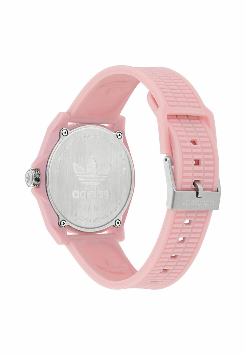 Montre avec bracelet en silicone rose, boîtier octogonal, dos en acier inoxydable et fermoir métallique ajustable. Présente un bracelet texturé et un détail de logo.