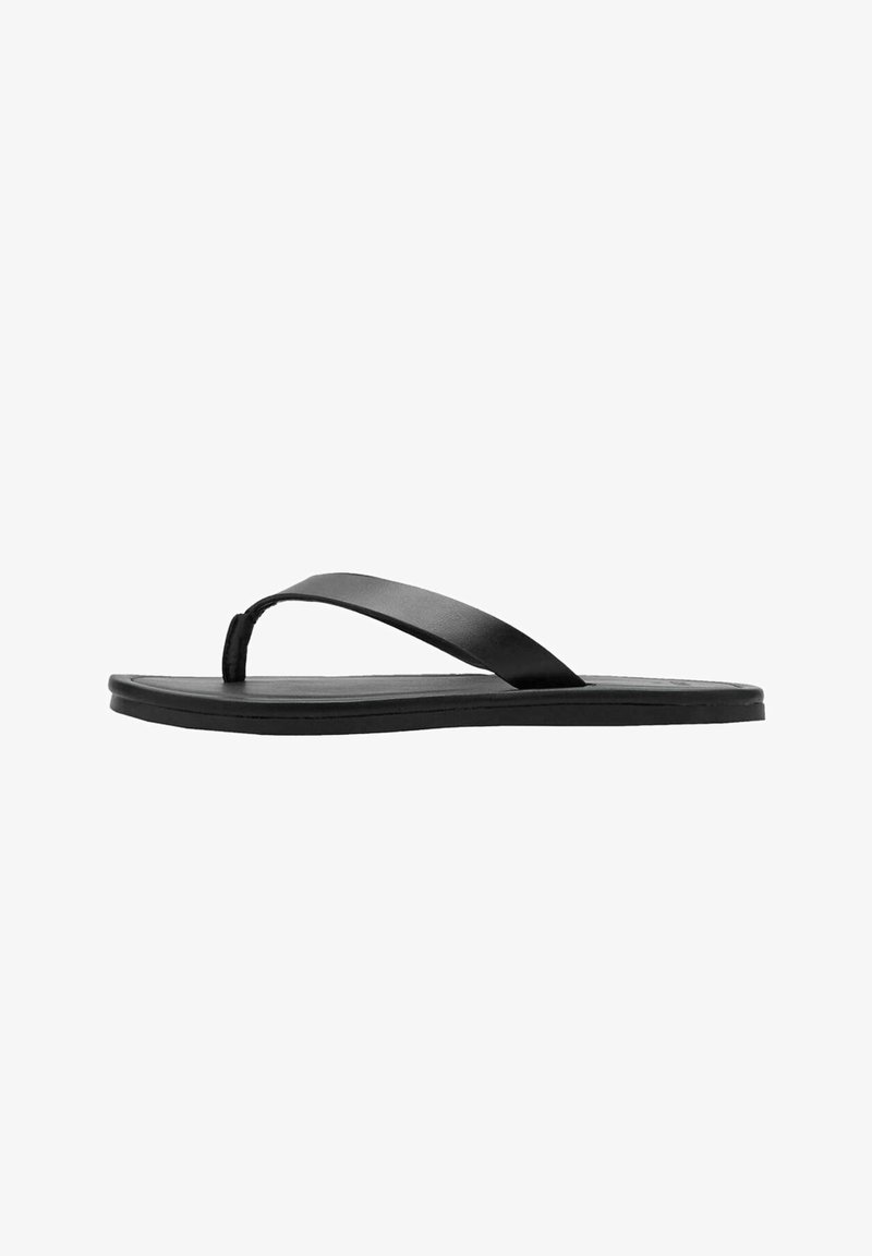 Sandale plate noire type tongs avec une bride simple et une semelle fine, montrée de profil sur fond blanc.