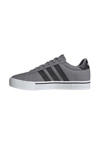 Gray canvas sneakers with three black stripes, white rubber sole, round toe, and lace-up design. Textured upper and contrasting sole stripes.