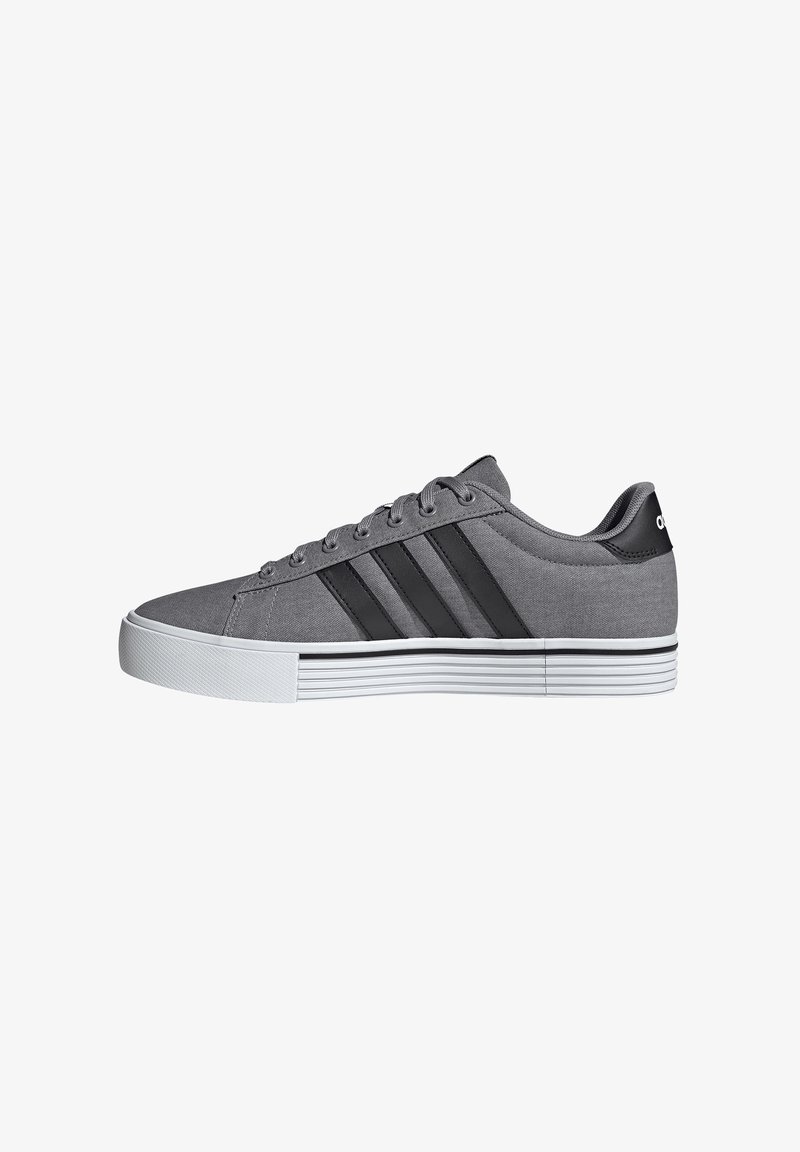 Gray canvas sneakers with three black stripes, white rubber sole, round toe, and lace-up design. Textured upper and contrasting sole stripes.