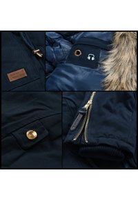 Marineblaue Jacke mit einem Kunstpelzkragen, versehen mit goldenen Akzenten, mehreren Reißverschlüssen und einem Kopfhöreranschluss am Ärmelsaum. Strukturierte Stoffpaneele.