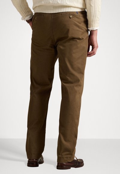 Brown cotton trousers with a straight leg design, featuring back pockets and a subtle texture. Finished with a simple button closure.