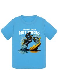 Jasnoniebieska bawełniana koszulka z grafiką przedstawiającą motocrossowca i motocykl, z plamami żółtej i zielonej wody poniżej.