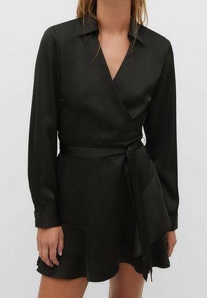 Robe noir portefeuille en tissu lisse avec manches longues, col et ceinture à la taille. Ourlet évasé et boutons aux poignets.