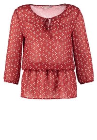 Blouse rouge transparente avec petit motif floral blanc, manches longues avec poignets élastiques, encolure ronde avec détail noué et taille froncée.