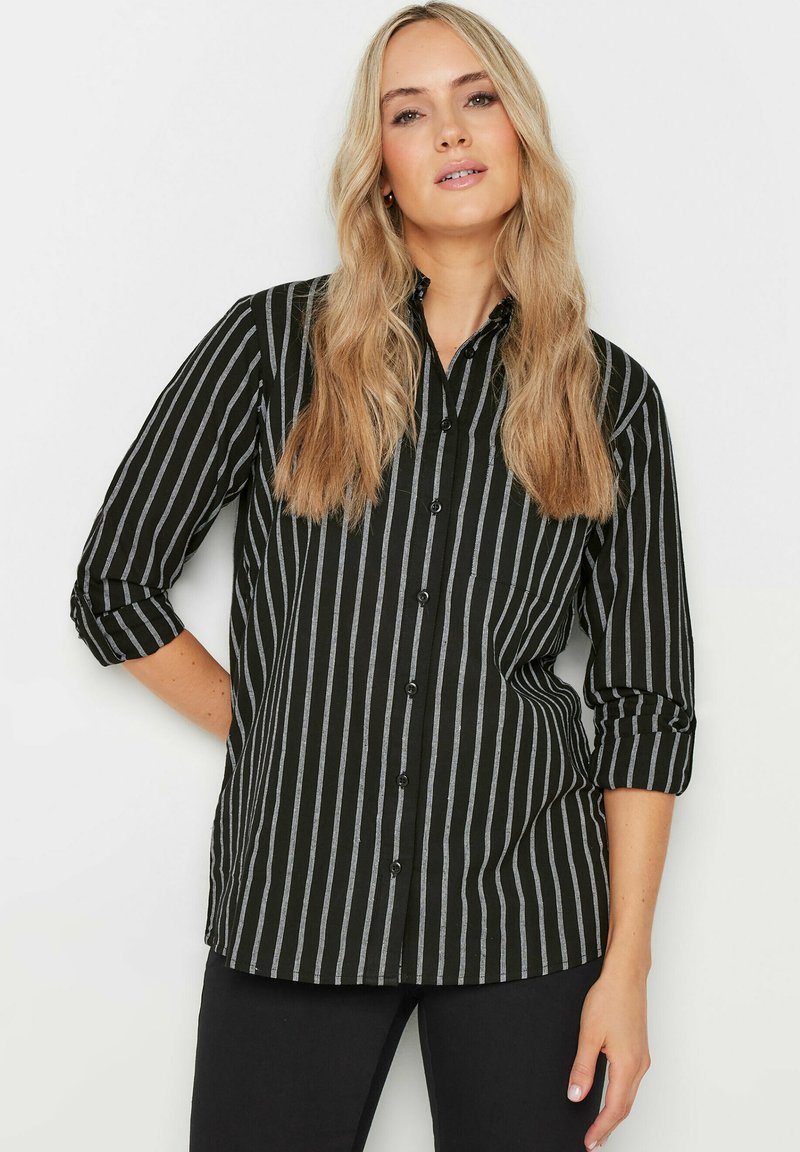 Camicia a righe nera e grigia con colletto, maniche arrotolabili e tasca frontale, realizzata in tessuto intrecciato.