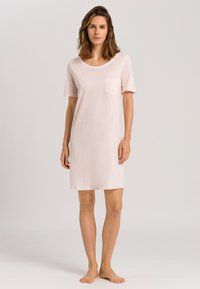 Ljusrosa kortärmad nattskjorta med rundad halsringning och bröstficka, tillverkad av mjukt material, knälång med en slät textur.
