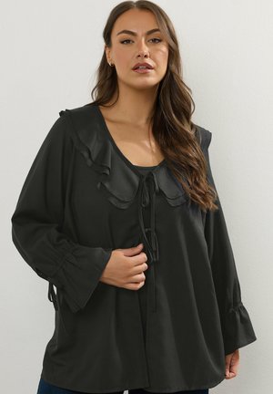 Schwarze Bluse mit langen Ärmeln, Rüschenausschnitt, Bindeband vorne und elastischen Ärmeln. Weicher Stoff mit fließender Silhouette.