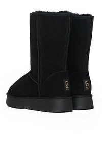 Botas de ante negro hasta la mitad de la pantorrilla con un suave forro interior, suela de goma gruesa y logo dorado "G" en el talón. Presenta costuras reforzadas.