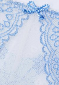 Spetstyg i ljusblått med ett delikat mönster, med vågiga kanter och en blå satinrosett som accent högst upp.