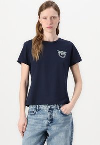 T-shirt blu navy a maniche corte in cotone con colletto tondo, caratterizzato da un design decorativo e colorato ricamato sul petto.