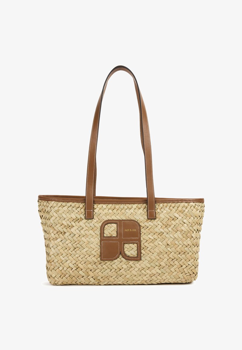 Sac cabas en paille tissée avec des poignées en similicuir marron et une pièce accentuée ornée d'un motif carré au centre.