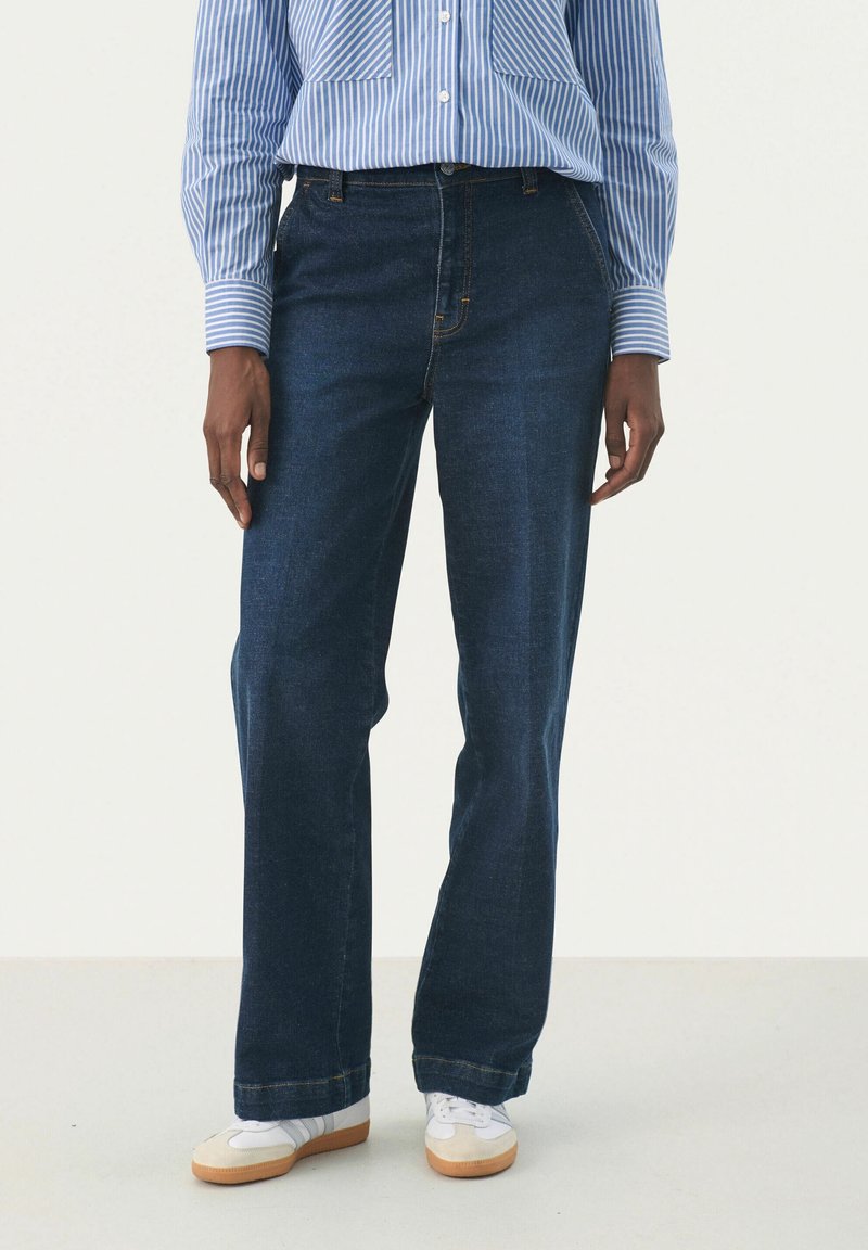 Jean en denim bleu foncé avec une coupe droite, comprenant un style classique à cinq poches et des coutures doubles.