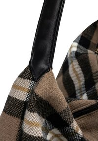 Borsa in tessuto a quadri con manico in pelle nera e tasca con zip visibile, caratterizzata da tonalità di marrone, nero, bianco e un motivo a scacchi beige.
