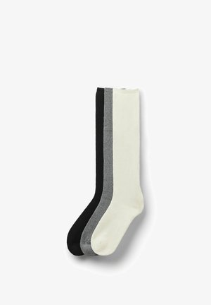 Ensemble de trois paires de chaussettes en noir, gris et crème. Fabriquées dans un tissu lisse, chaque paire de chaussettes présente un bord côtelé et un design uni.