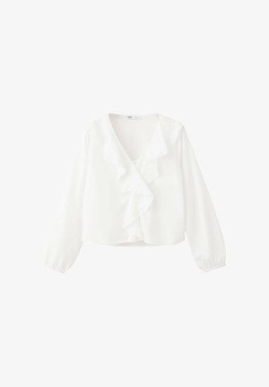 Blouse blanche à manches longues avec col en V et détail volanté sur le devant, poignets élastiques et coupe légèrement courte sur un fond uni.
