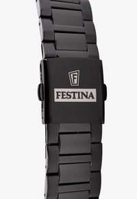 Montre en métal noir avec un bracelet à maillons poli et un boîtier carré. Présente un logo argenté sur un fond noir mat.