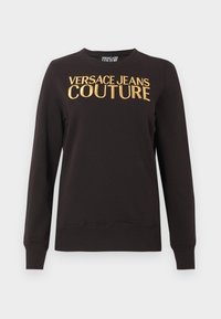 Sudadera negra de manga larga con puños y bajo acanalados, con un gran texto dorado "VERSACE JEANS COUTURE" en el pecho.