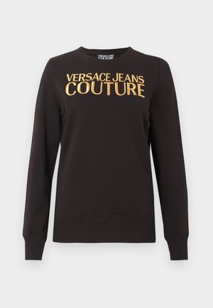 Črno dolg rokav z rebrastimi manšetami in robom, na prsih z velikim zlatim napisom "VERSACE JEANS COUTURE".